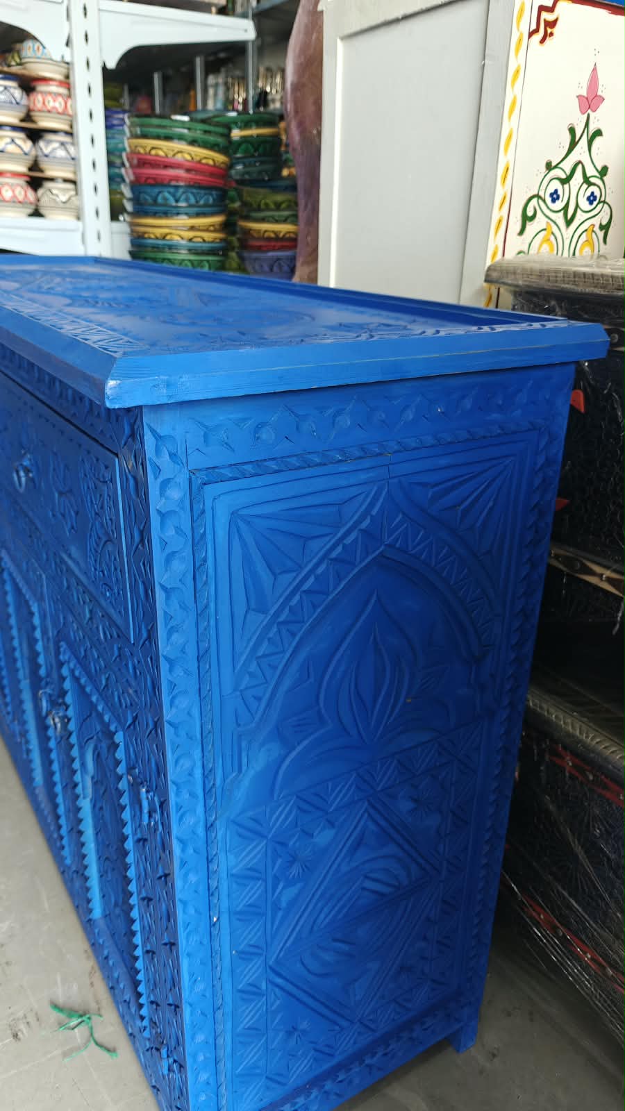 Lateral azul del aparador con panel de madera tallada y borde de la tapa