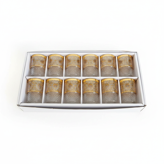Set de 12 vasos de té marroquí con grabado dorado sobre fondo blanco, fotografía de producto profesional