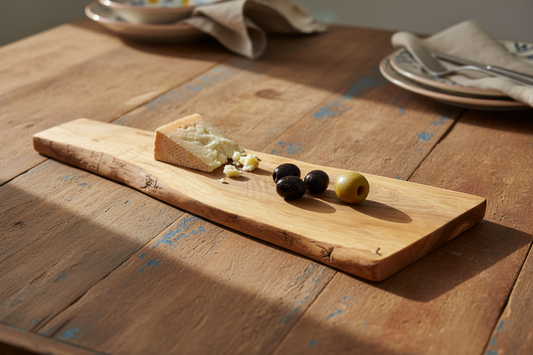 Tabla de olivo artesanal en ambiente andaluz con queso y aceitunas