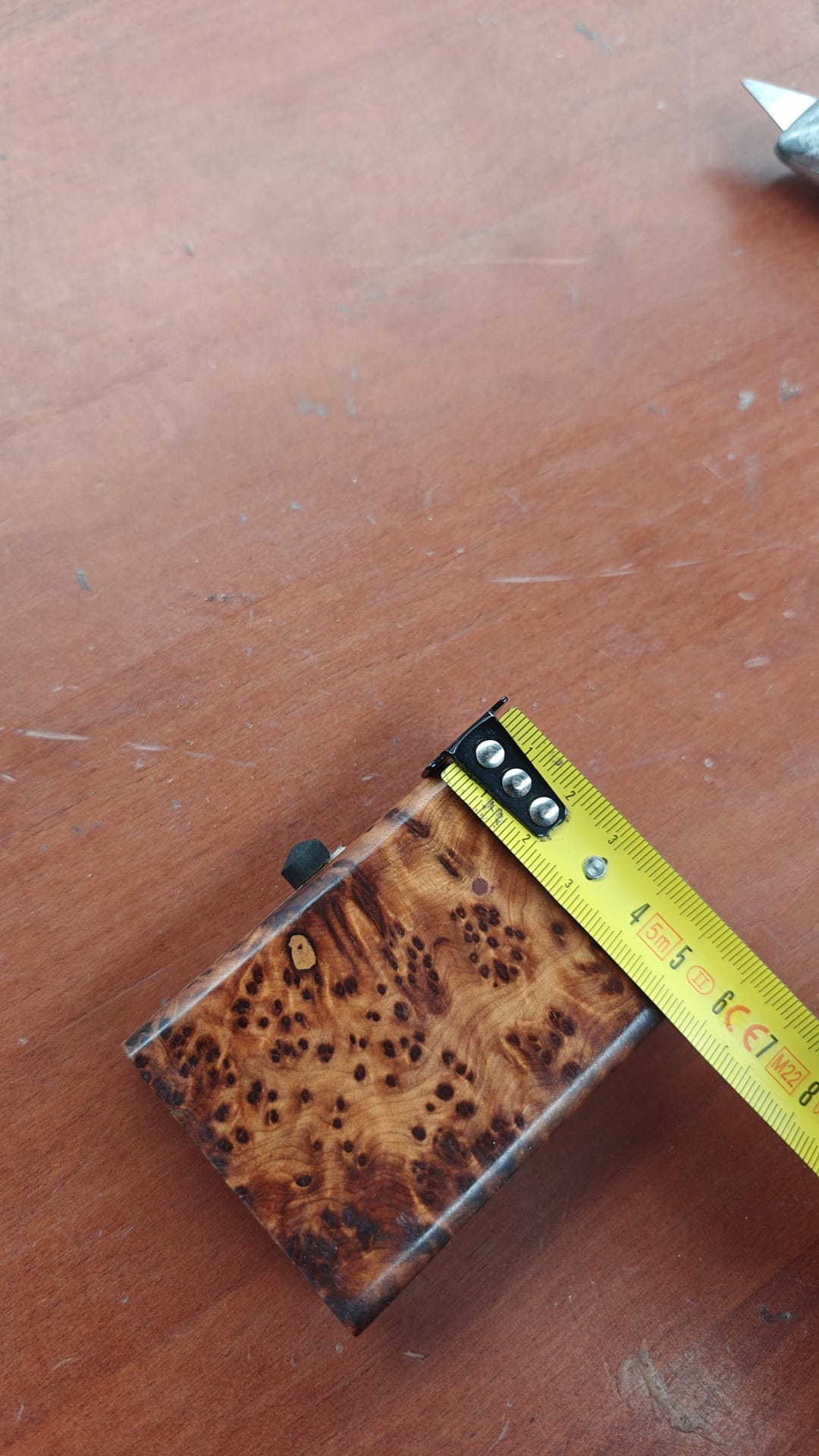 Vista superior de caja sorpresa en madera de tuya con veta natural dorada y marrón, medidas aproximadas 7 cm