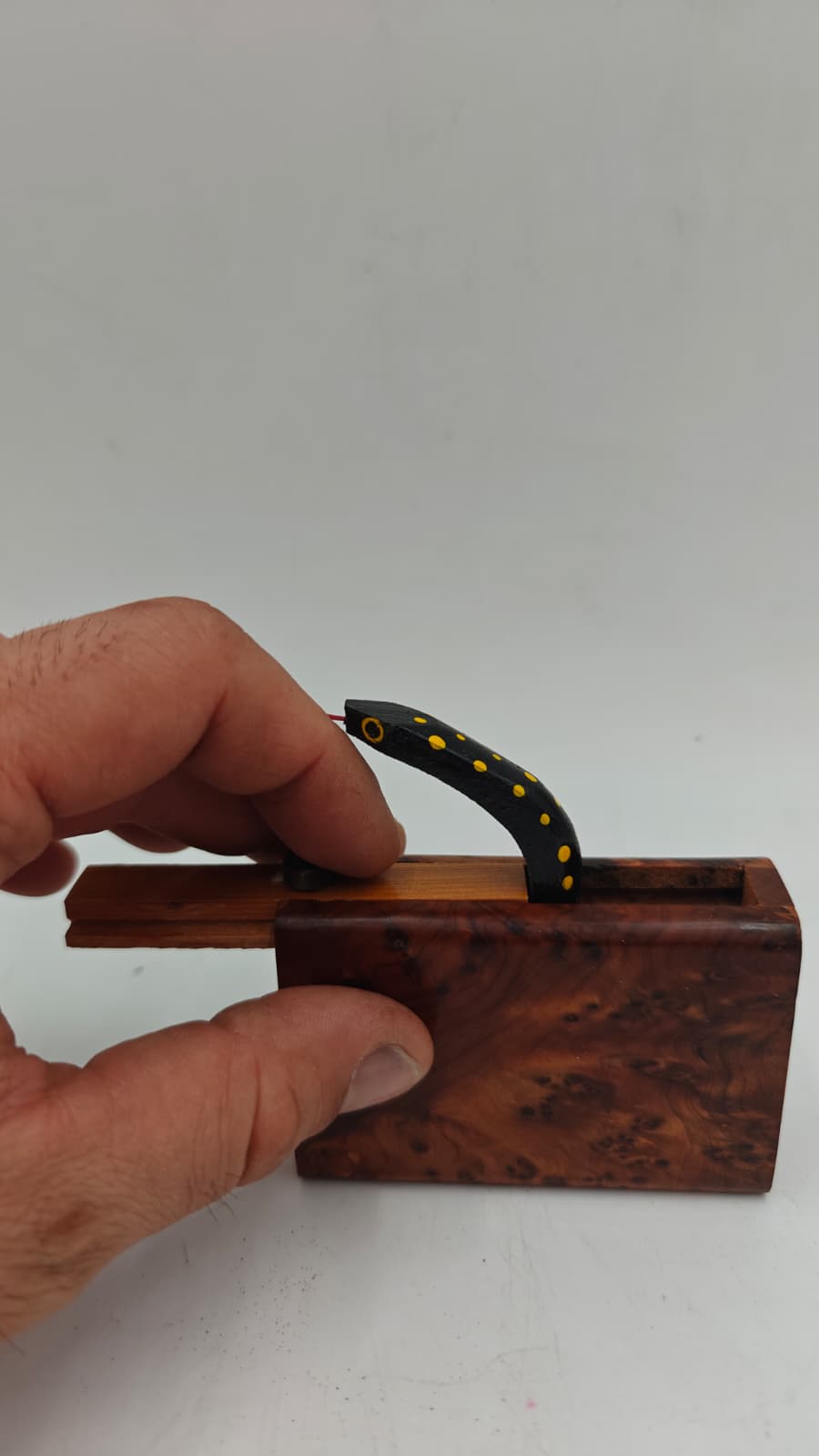 Detalle del mecanismo de resorte de la caja sorpresa serpiente en madera de tuya marroquí