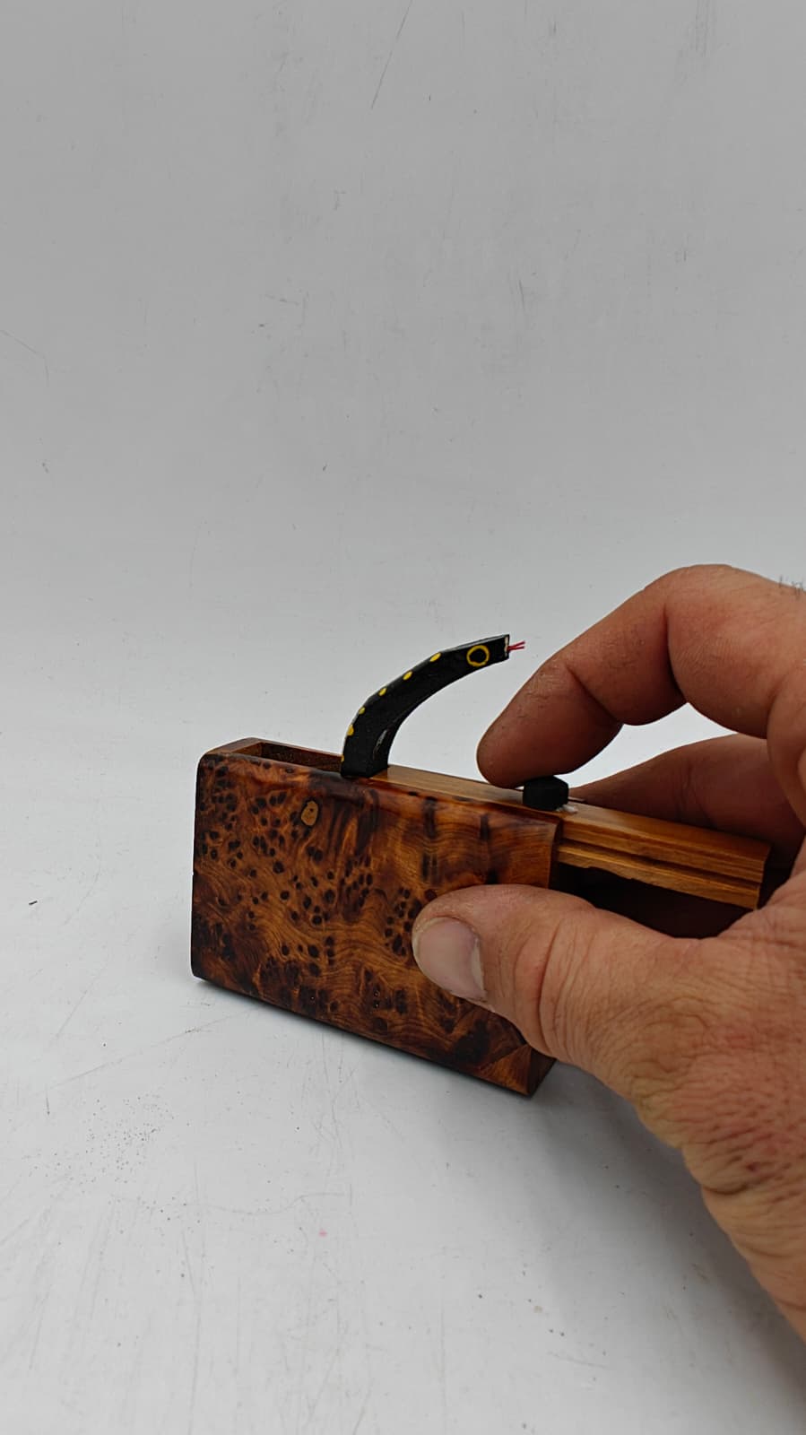 Caja sorpresa serpiente en madera de raíz de tuya, vista lateral mostrando grosor y acabado en goma laca