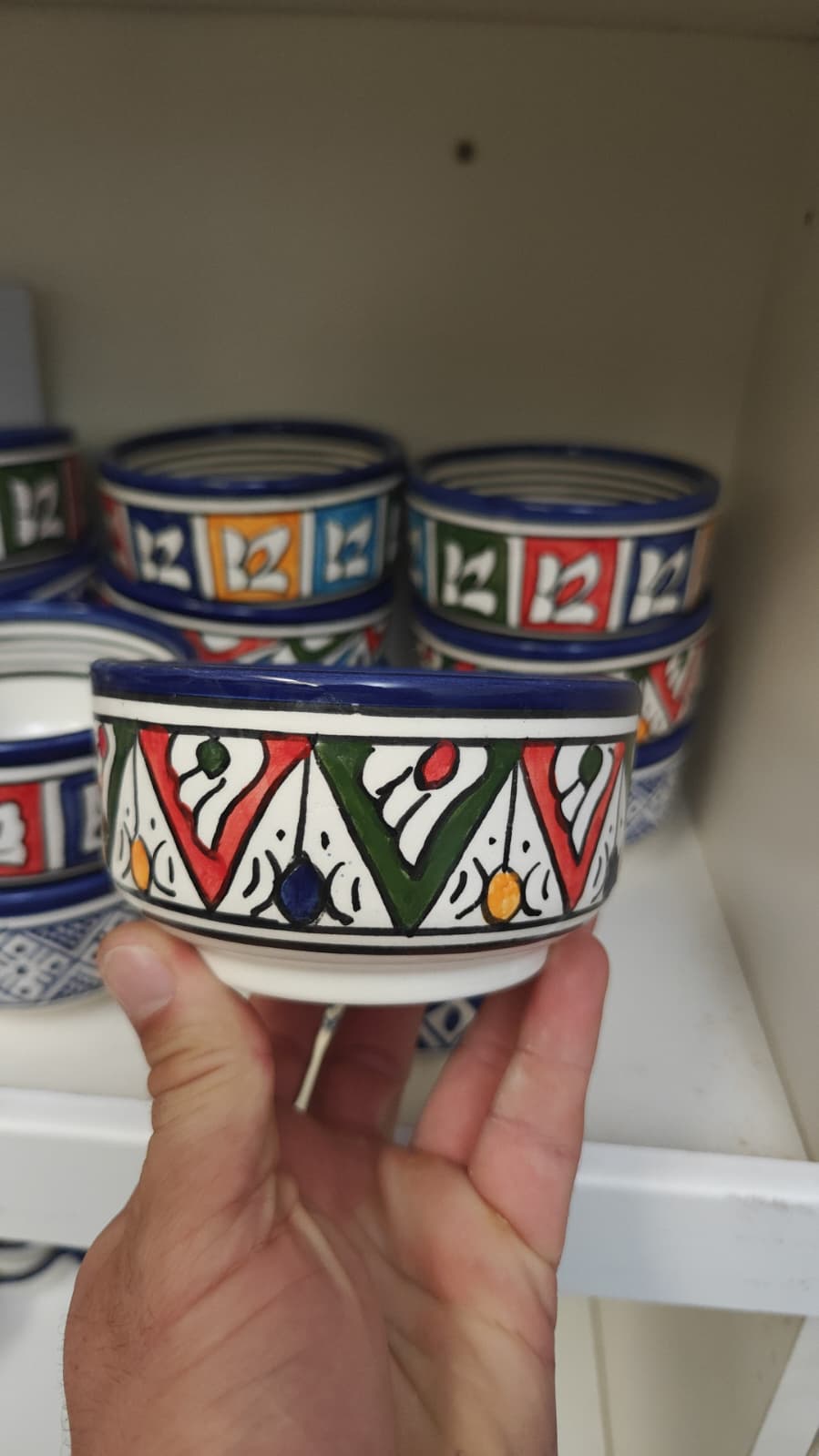 Cuenco de cerámica blanca pintado a mano con motivos geométricos multicolor y borde azul