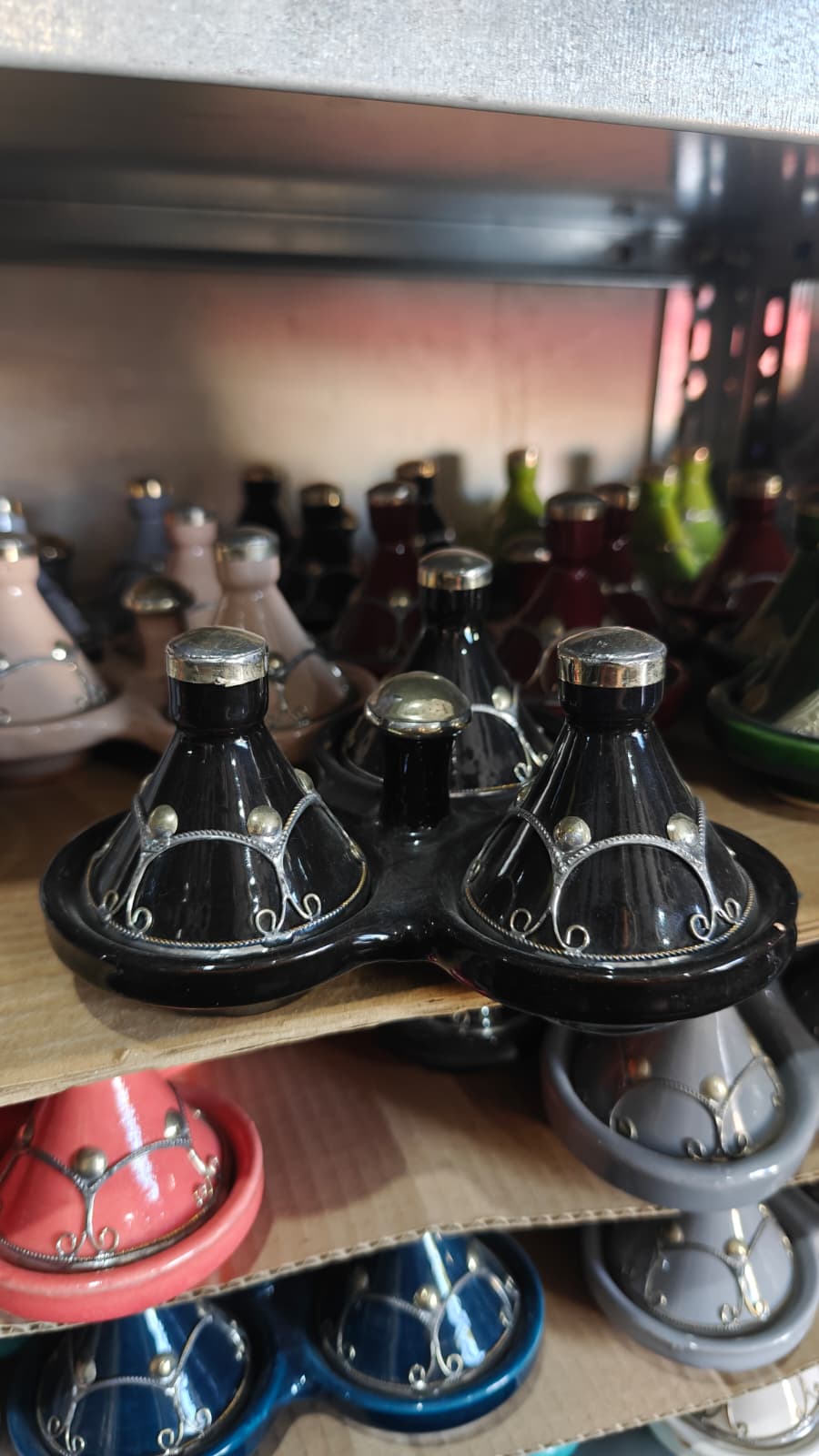 Tajines mini especieros triples artesanales en varios colores colocados en una estantería
