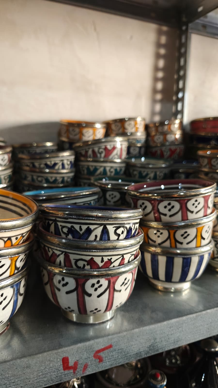Cuencos de Fez artesanales con dibujos geométricos y colores surtidos en una estantería