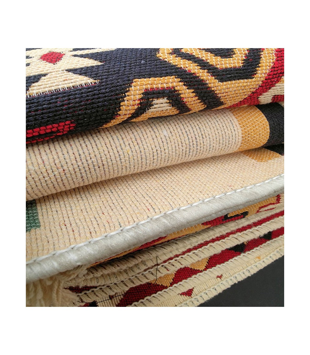 Detalle del tejido artesanal de alfombras kilim turcas enrolladas mostrando calidad y colores vivos