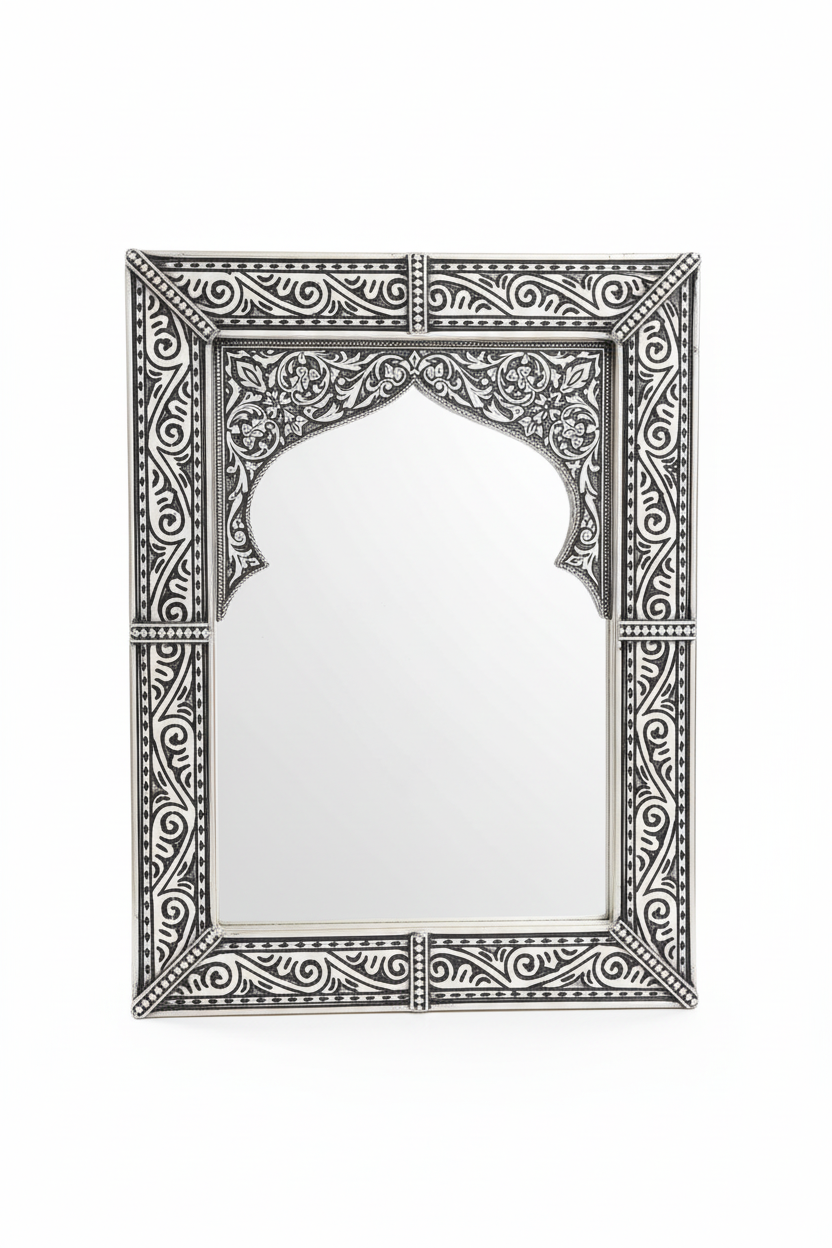 Espejo árabe de alpaca tallada negro y plata con arco morisco y arabescos florales sobre fondo blanco, artesanía marroquí