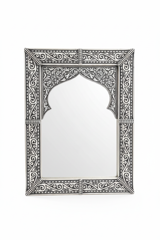 Espejo árabe de alpaca tallada negro y plata con arco morisco y arabescos florales sobre fondo blanco, artesanía marroquí