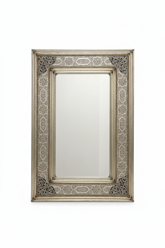 Espejo marroquí de alpaca repujada plateada sobre fondo blanco, marco con arabescos artesanales de Fez