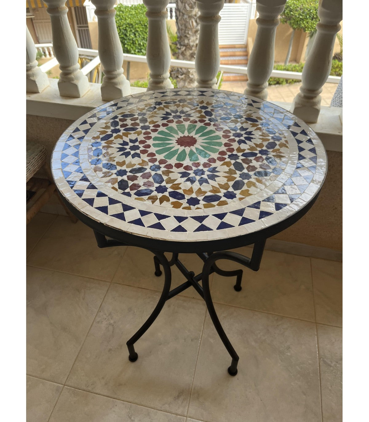 Mesa de jardín mosaico zellige con base de hierro forjado en terraza exterior – artesania de Fez Marruecos
